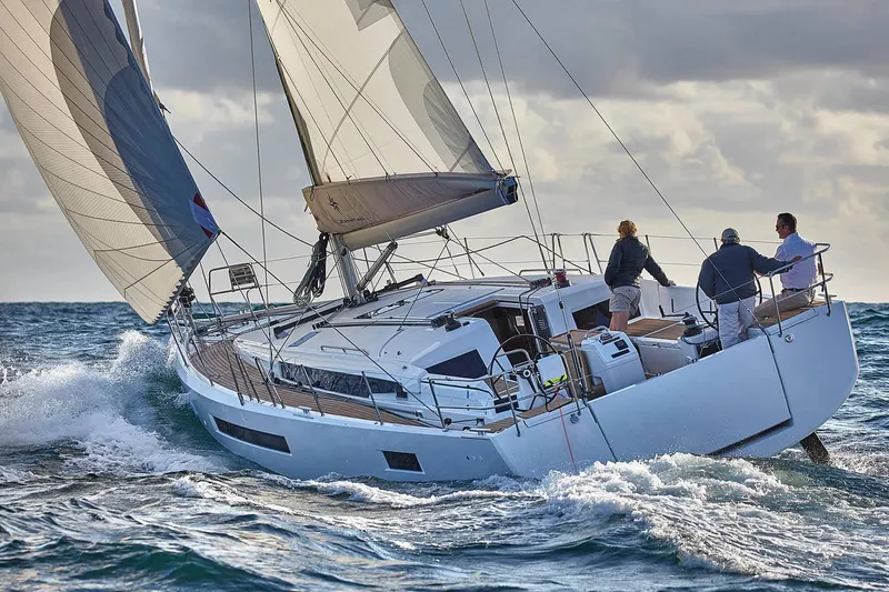 Slide: The Image of 2026 Jeanneau Sun Odyssey 490 sailing on open sea with three people onboard. - 2