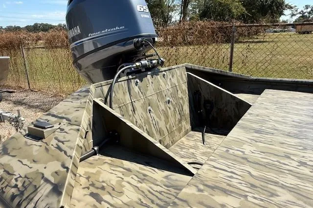 Slide: The Image of 2025 SeaArk 1860 MVJT boat with Yamaha engine, camo design, outdoor setting. - 2