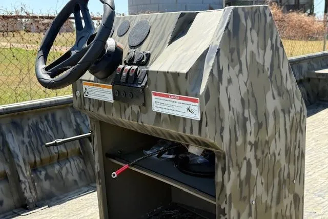 Slide: The Image of 2025 SeaArk 1860 MVJT boat console with camouflage design and steering wheel. - 3