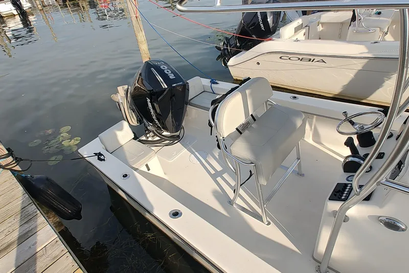 Slide: The Image of 2024 Mayfield 238CC boat docked, featuring a sleek design and powerful outboard motor. - 5