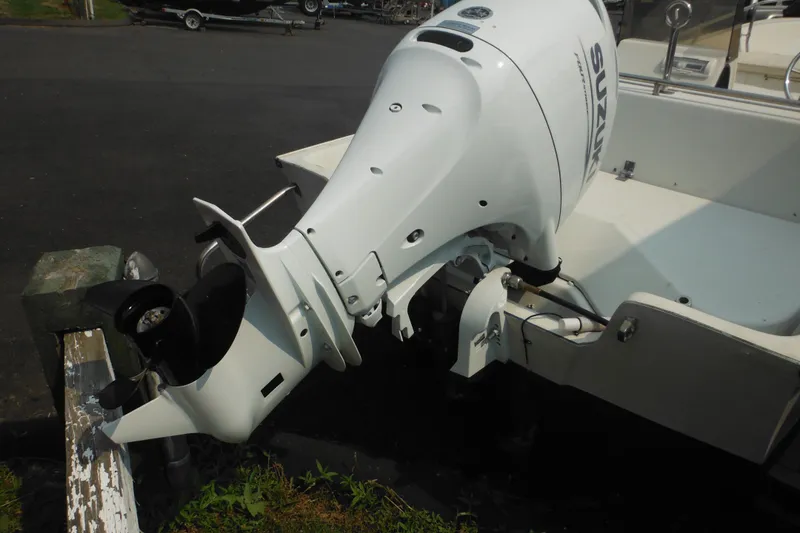 Slide: The Image of 1988 Boston Whaler 17 Super Sport with Suzuki outboard motor, docked on pavement. - 11