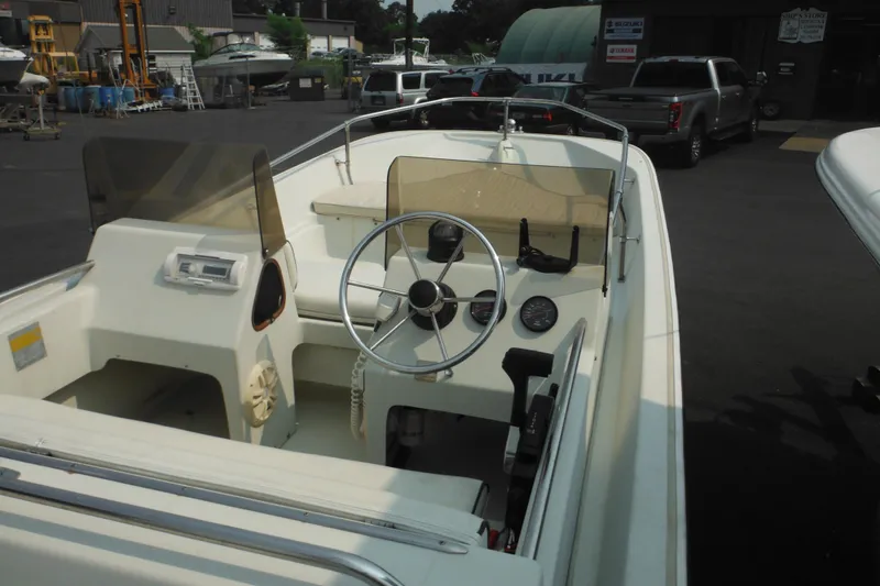 Slide: The Image of 1988 Boston Whaler 17 Super Sport boat interior with steering wheel and dashboard controls. - 13