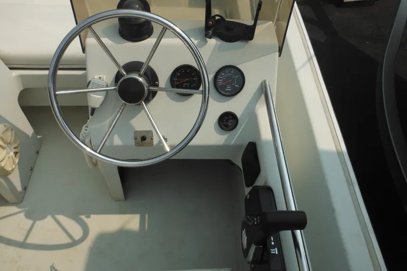 Slide: The Image of 1988 Boston Whaler 17 Super Sport boat dashboard with steering wheel and gauges. - 17