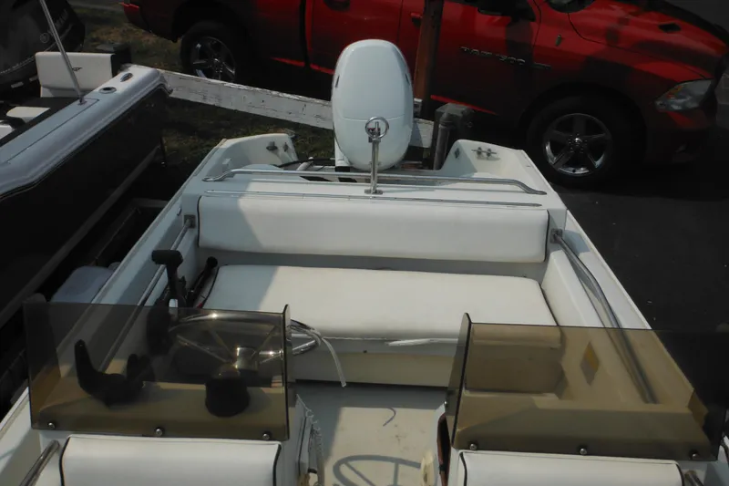 Slide: The Image of 1988 Boston Whaler 17 Super Sport boat interior with white seating and steering console. - 20