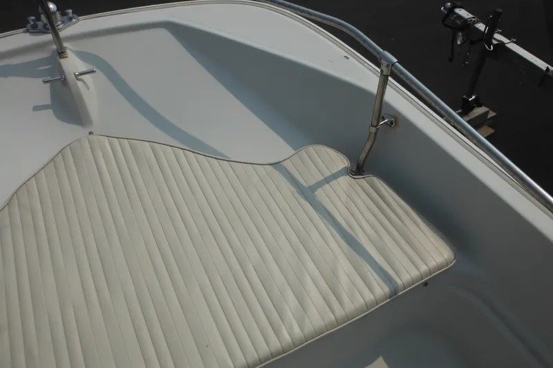 Slide: The Image of 1988 Boston Whaler 17 Super Sport boat interior with cushioned seating and metal railing. - 24