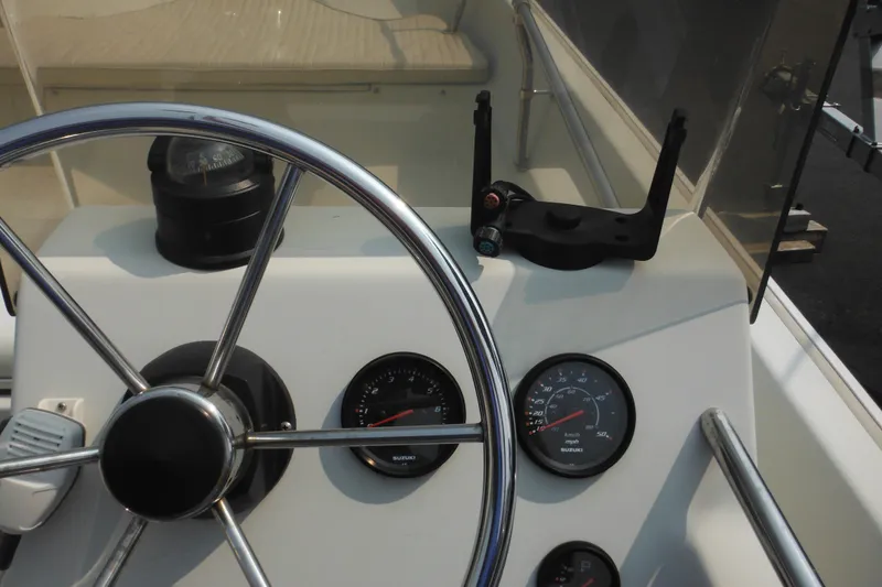 Slide: The Image of Steering wheel and gauges of a 1988 Boston Whaler 17 Super Sport boat. - 32