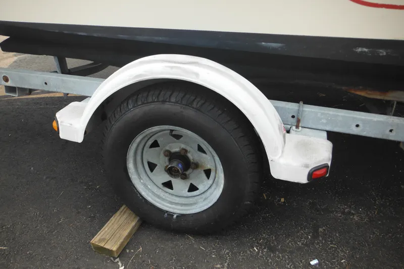 Slide: The Image of Trailer wheel of a 1988 Boston Whaler 17 Super Sport boat on a wooden block. - 40