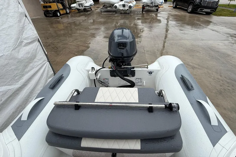 Slide: The Image of 2026 Gala A300L inflatable boat with motor, parked on wet concrete surface. - 11