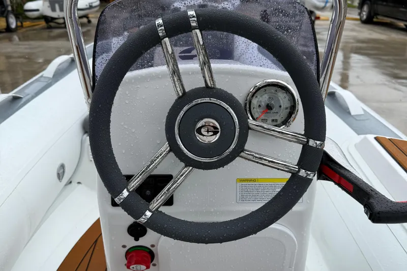 Slide: The Image of Steering wheel of 2026 Gala A300L boat, wet with raindrops, featuring a speedometer. - 5