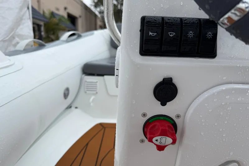 Slide: The Image of Control panel of 2026 Gala A300L boat with switches and ignition, wet from rain. - 6