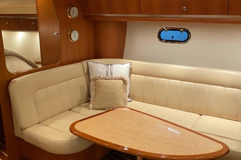 Slide: The Image of 2005 Tiara Yachts 3600 Sovran interior with beige seating and wooden table. - 23
