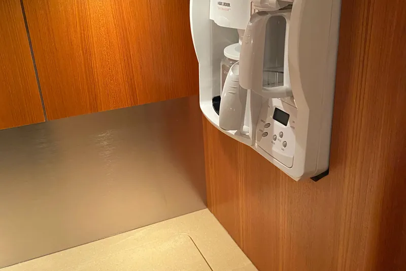 Slide: The Image of 2005 Tiara Yachts 3600 Sovran galley with built-in coffee maker and wooden cabinetry. - 25