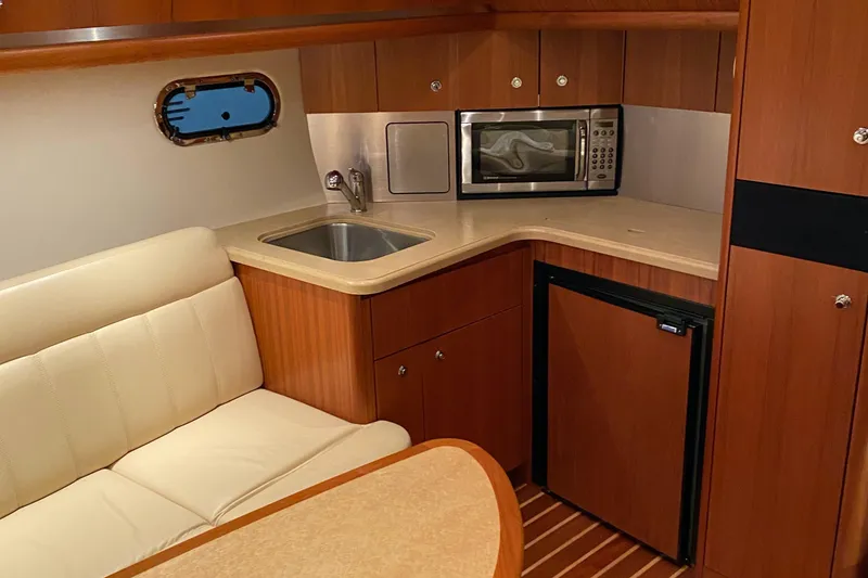 Slide: The Image of 2005 Tiara Yachts 3600 Sovran interior with kitchenette, sink, microwave, and seating area. - 26