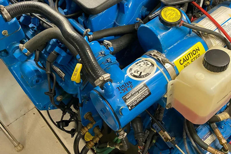 Slide: The Image of Engine components of a 2005 Tiara Yachts 3600 Sovran, featuring blue machinery and caution labels. - 46