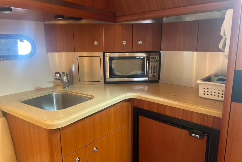 Slide: The Image of 2005 Tiara Yachts 3600 Sovran kitchen with sink, microwave, and wooden cabinetry. - 49