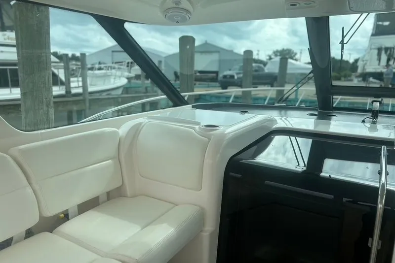 Slide: The Image of Interior view of 2005 Tiara Yachts 3600 Sovran, featuring white seating and marina backdrop. - 66