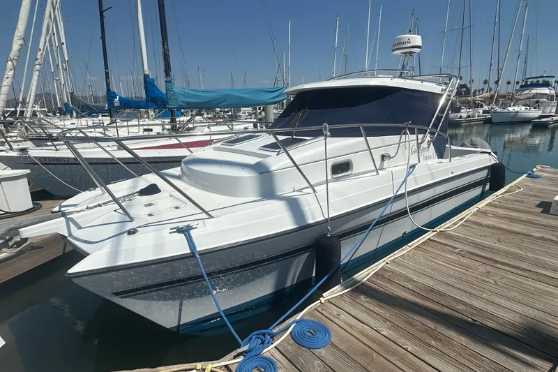 The Image of 2004 Glacier Bay 2680 Coastal Runner docked at marina, surrounded by sailboats. - 1