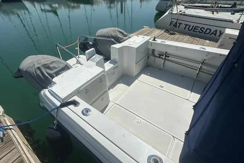 Slide: The Image of 2004 Glacier Bay 2680 Coastal Runner boat docked, featuring spacious deck and covered engines. - 10