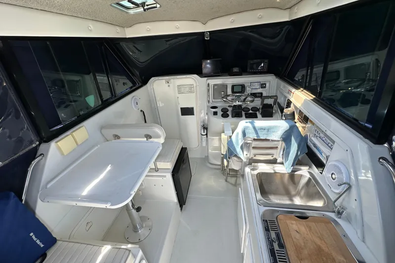 Slide: The Image of 2004 Glacier Bay 2680 Coastal Runner interior with helm, seating, and kitchenette. - 7