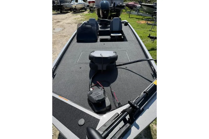 Slide: The Image of 2026 Lowe Legacy boat deck with seating and equipment, parked outdoors. - 2