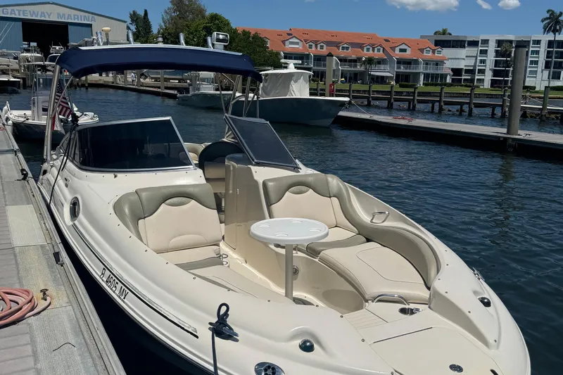 The Image of 2005 Sea Ray 270 SLX boat on trailer, parked outdoors under clear blue sky. - 0