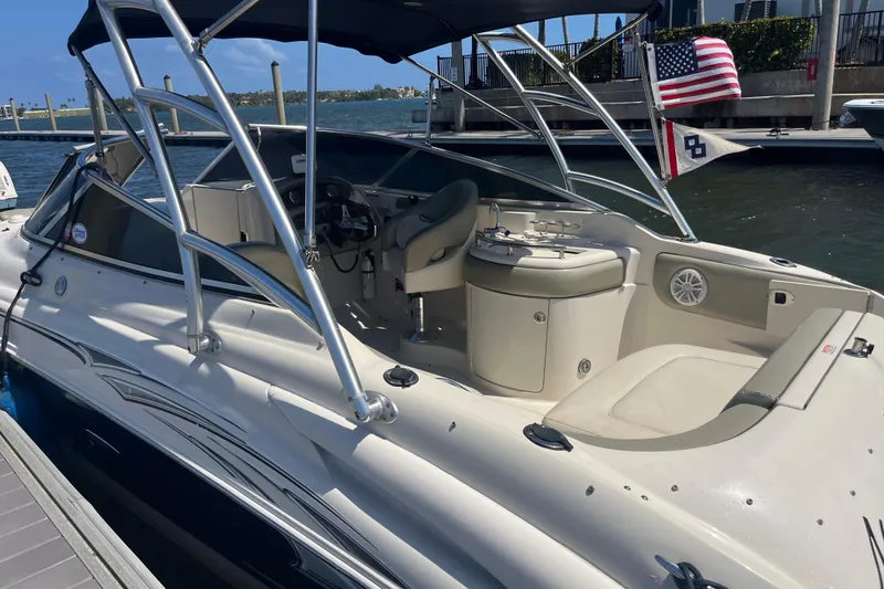 Slide: The Image of 2005 Sea Ray 270 SLX boat on trailer, parked outdoors with trees in background. - 2