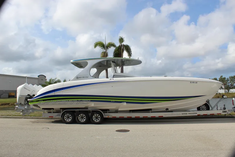 Slide: The Image of 2020 Mystic Powerboats M4200 on trailer, sleek design with blue and green accents. - 16