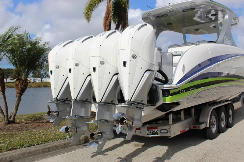 Slide: The Image of 2020 Mystic Powerboats M4200 with quad engines on a trailer by a lakeside. - 22