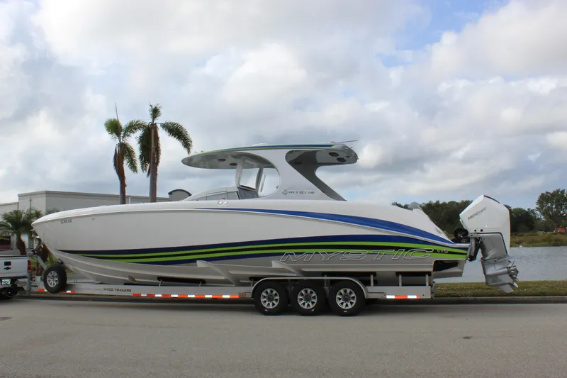 Slide: The Image of 2020 Mystic Powerboats M4200 on trailer, sleek design with vibrant blue and green accents. - 6