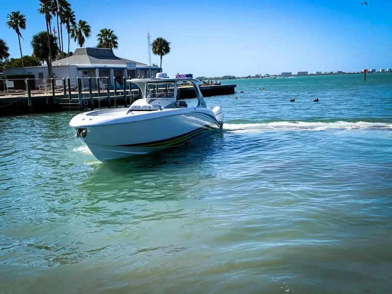 Slide: The Image of 2020 Mystic Powerboats M4200 cruising in sunny coastal waters near a dock. - 61