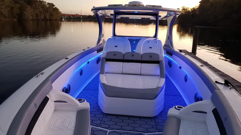 Slide: The Image of 2020 Mystic Powerboats M4200 with blue LED lights on a serene waterway. - 68