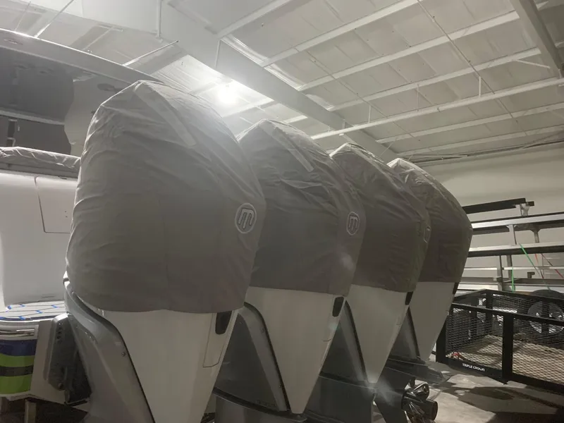 Slide: The Image of Four covered outboard motors on a 2020 Mystic Powerboats M4200 in a storage facility. - 69