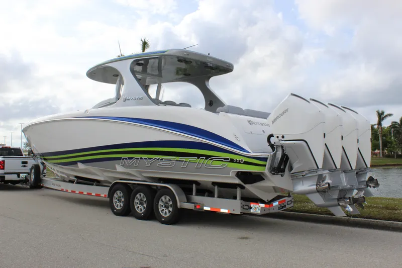 Slide: The Image of 2020 Mystic Powerboats M4200 on trailer with triple engines, parked by waterfront. - 7