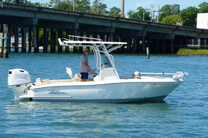 Slide: The Image of 2021 Pioneer 202 Islander boat on water near a bridge, featuring Suzuki outboard motor. - 1