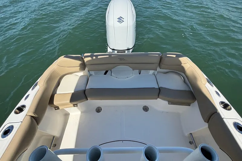 Slide: The Image of 2021 Pioneer 202 Islander boat interior with cushioned seating and outboard motor on water. - 10