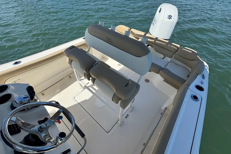 Slide: The Image of 2021 Pioneer 202 Islander boat interior with seating and steering wheel on water. - 11