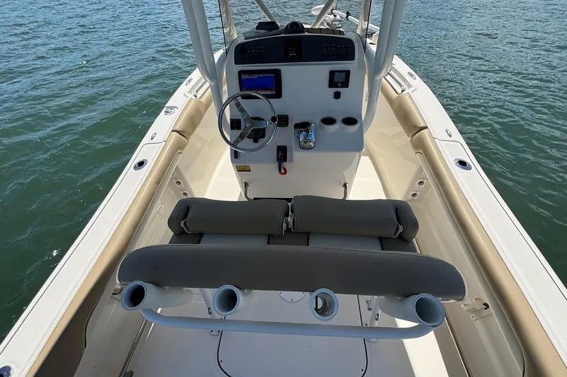 Slide: The Image of 2021 Pioneer 202 Islander boat interior with steering console and seating, on calm water. - 12