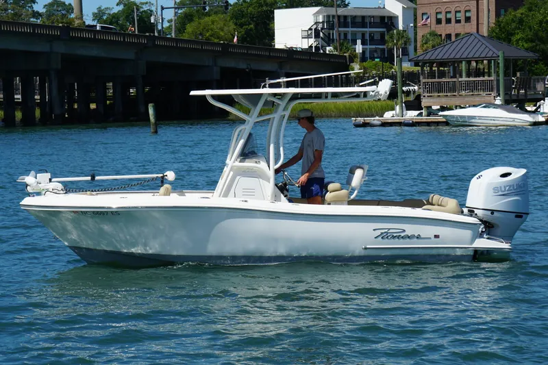 Slide: The Image of 2021 Pioneer 202 Islander boat cruising on a sunny day near a bridge. - 5