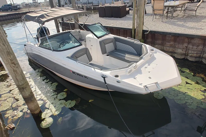 The Image of 2026 NauticStar 223 DC Deck boat docked, featuring sleek design and spacious seating. - 1