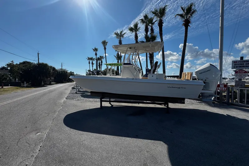 Slide: The Image of 2026 Ranger 2360 Bay boat with Mercury engine, parked outdoors under clear sky. - 1