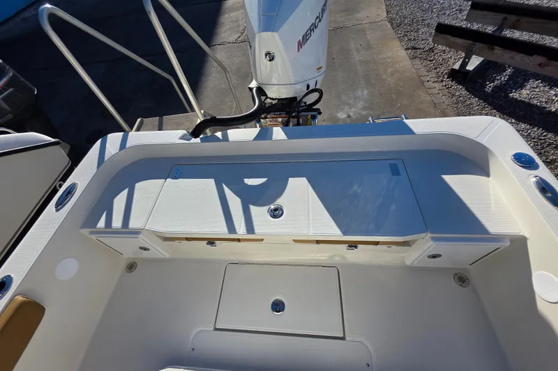 Slide: The Image of 2026 Ranger 2360 Bay boat interior with Mercury engine, showcasing storage compartments. - 19