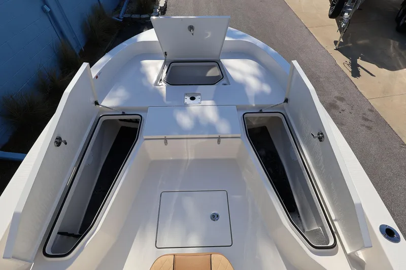 Slide: The Image of 2026 Ranger 2360 Bay boat with open storage compartments on deck. - 23