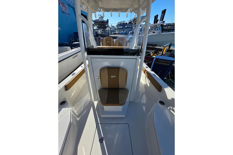 Slide: The Image of 2026 Ranger 2360 Bay boat interior with seating and console, docked at a marina. - 31