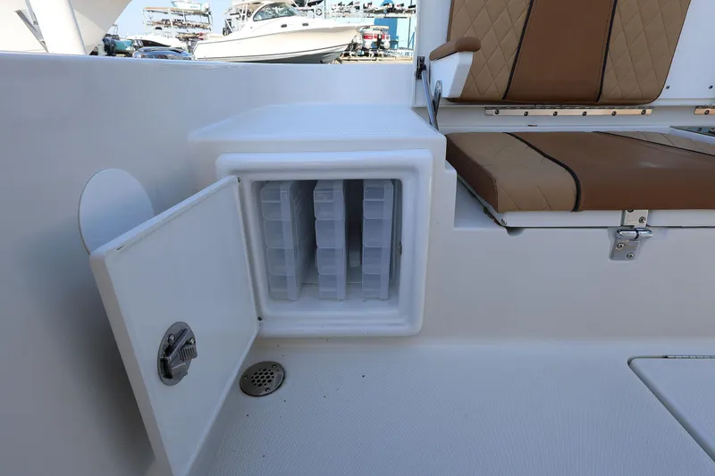 Slide: The Image of 2026 Ranger 2360 Bay boat storage compartment with open door and cushioned seating. - 47