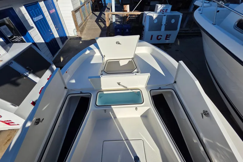 Slide: The Image of 2026 Ranger 2360 Bay boat with open storage compartments and ice boxes on deck. - 8