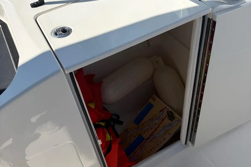 Slide: The Image of 2024 Bayliner VR6 Bowrider OB storage compartment with life jackets and boat accessories. - 7