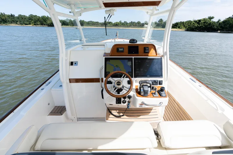 Slide: The Image of 2019 Hunt Yachts 32CC boat cockpit with modern navigation system and wooden accents. - 15