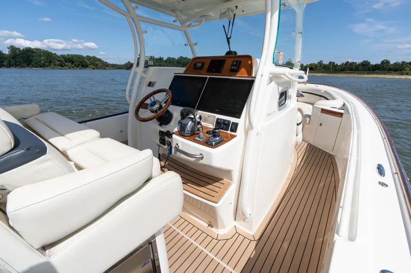 Slide: The Image of 2019 Hunt Yachts 32CC boat interior with helm, steering wheel, and navigation equipment. - 20