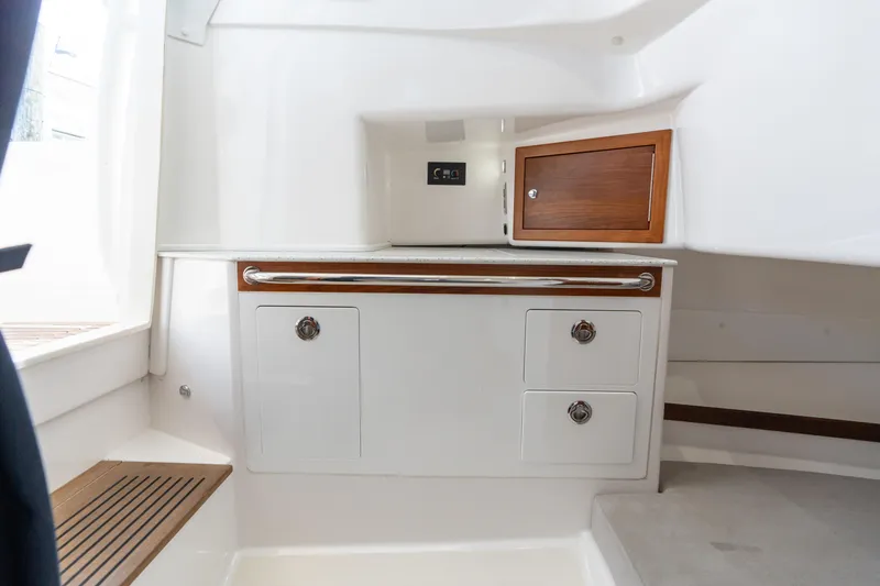 Slide: The Image of 2019 Hunt Yachts 32 Center Console interior with storage cabinets and wooden accents. - 24