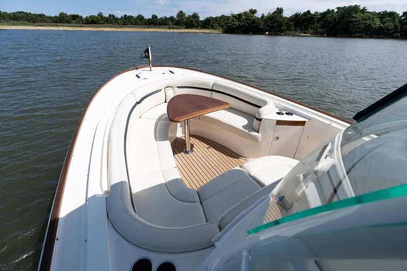 Slide: The Image of 2019 Hunt Yachts 32CC boat with elegant seating and wooden table on calm water. - 29